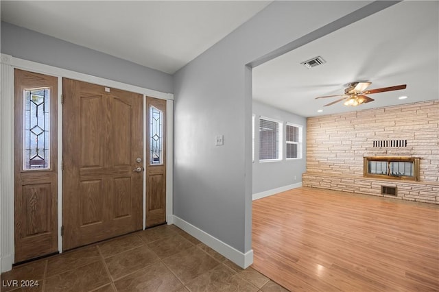 entrance foyer with a fireplace, hardwood / wood-style floors, and ceiling fan