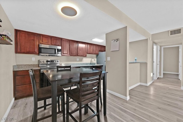 kitchen featuring stainless steel appliances, light hardwood / wood-style floors, and sink