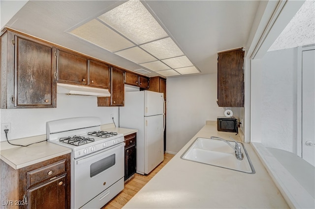 kitchen featuring sink, white appliances, and light wood-type flooring