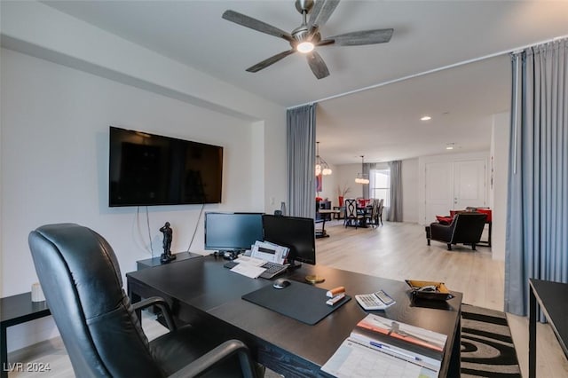 office with light wood-type flooring and ceiling fan