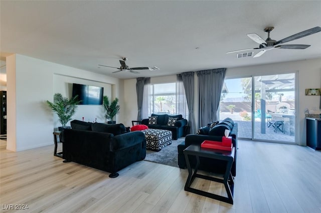 living room featuring light hardwood / wood-style flooring and ceiling fan