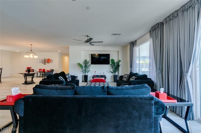 living room featuring hardwood / wood-style floors and ceiling fan with notable chandelier