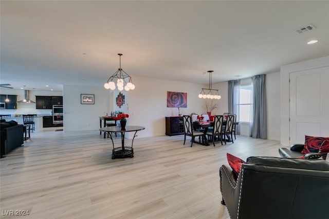 living area featuring light wood-style floors, visible vents, a notable chandelier, and recessed lighting