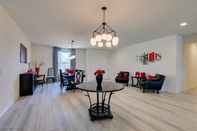 dining space with a chandelier and light hardwood / wood-style flooring