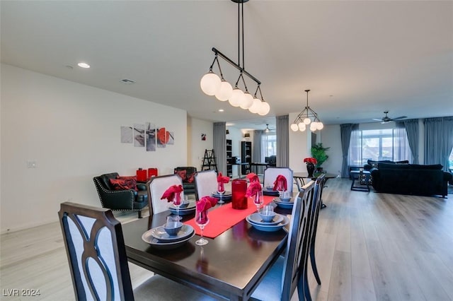 dining room featuring ceiling fan with notable chandelier and light wood-type flooring