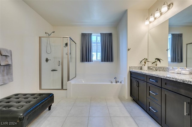 bathroom featuring tile patterned flooring, vanity, a bath, and a shower stall