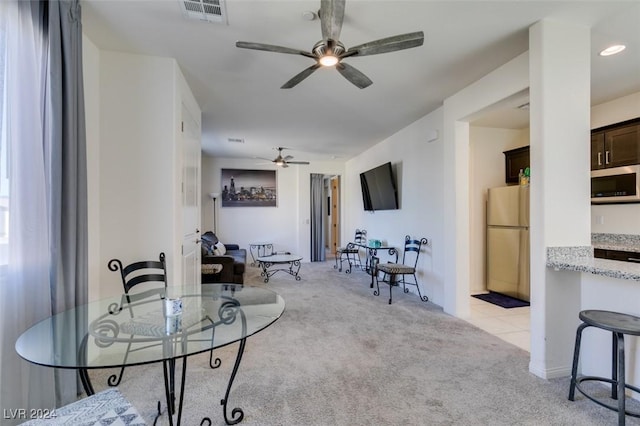 dining space featuring light carpet, ceiling fan, and visible vents