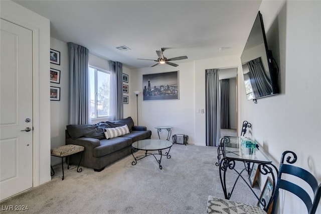 carpeted living room with ceiling fan and visible vents