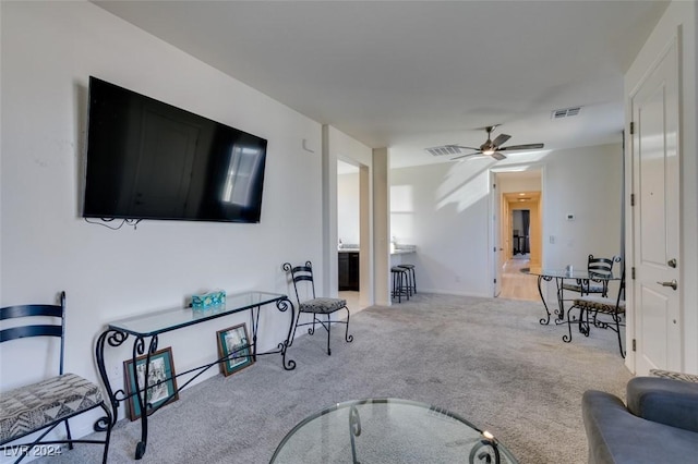 living room with ceiling fan and light colored carpet