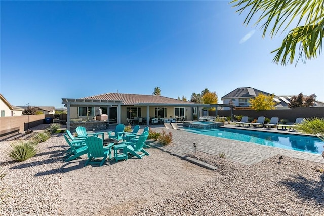 view of swimming pool featuring a patio area, a fenced backyard, and a pool with connected hot tub