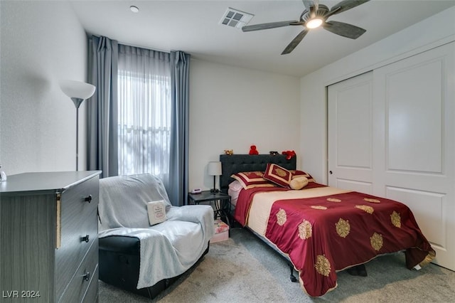 bedroom featuring a ceiling fan, a closet, visible vents, and carpet flooring