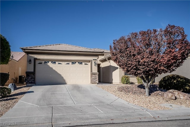 ranch-style home with central air condition unit and a garage