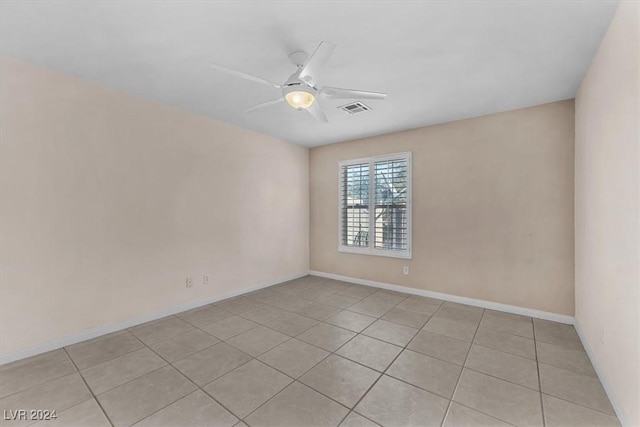 tiled empty room featuring ceiling fan