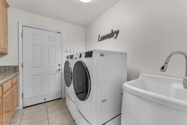 laundry area featuring cabinets, light tile patterned floors, separate washer and dryer, and sink