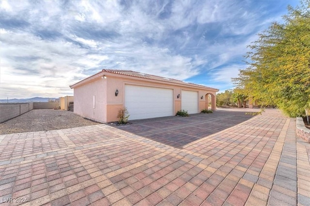 view of property exterior with a garage and an outdoor structure