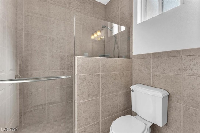 bathroom featuring toilet, walk in shower, and tile walls