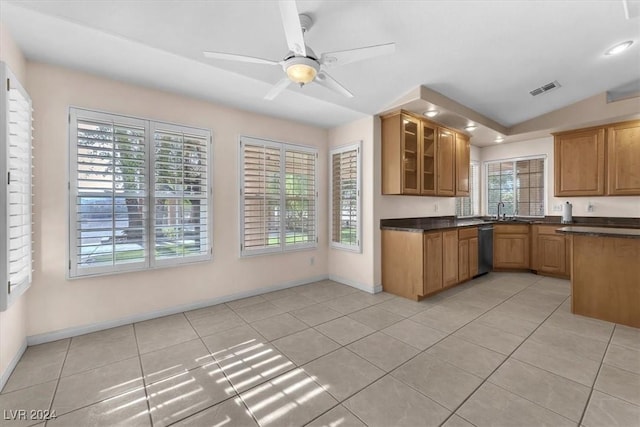 kitchen with ceiling fan, dishwasher, sink, vaulted ceiling, and light tile patterned floors