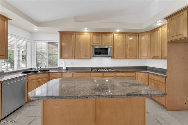 kitchen with a center island, stainless steel appliances, vaulted ceiling, and sink