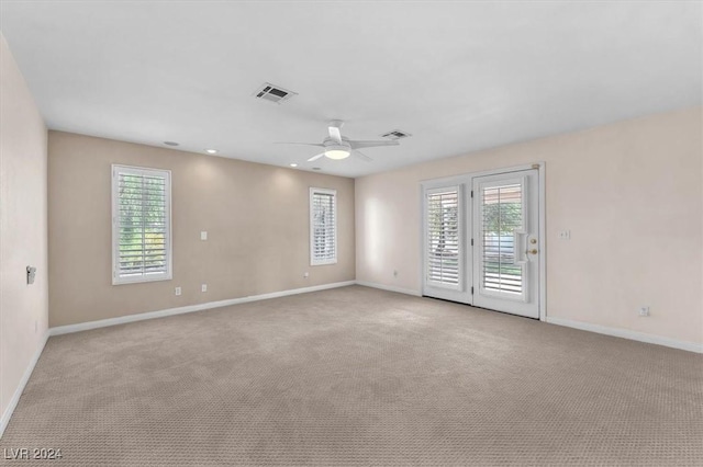 spare room with ceiling fan and light colored carpet