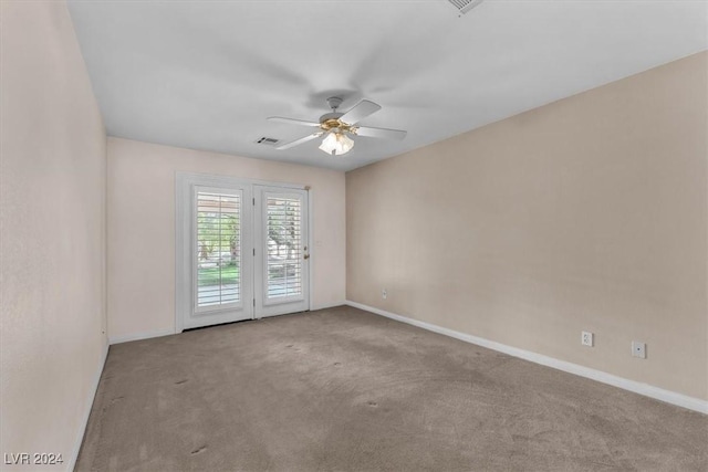 empty room with ceiling fan and light colored carpet