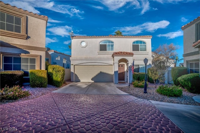 mediterranean / spanish-style home with a garage