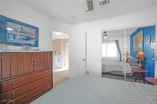 bedroom featuring ceiling fan, a closet, and light colored carpet