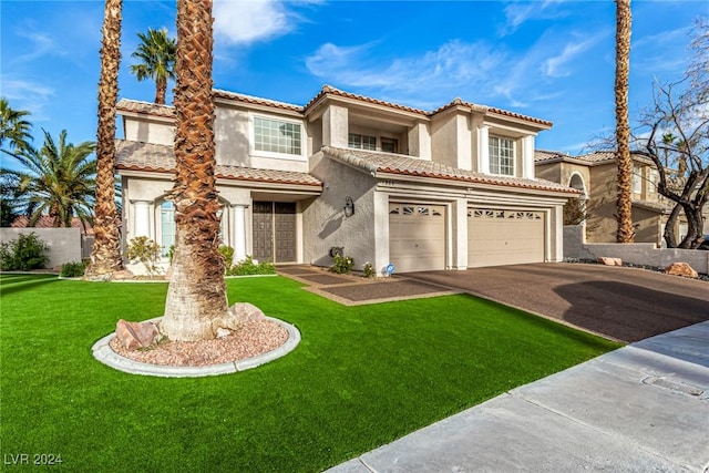 mediterranean / spanish house featuring a front yard and a garage