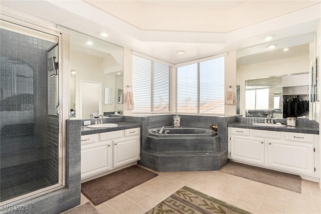 bathroom featuring plus walk in shower, tile patterned flooring, and vanity