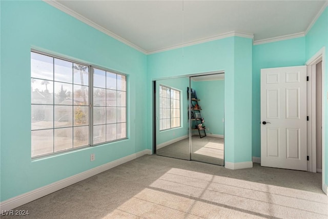 unfurnished bedroom featuring light colored carpet, a closet, and crown molding