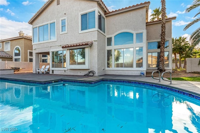 back of house with a fenced in pool