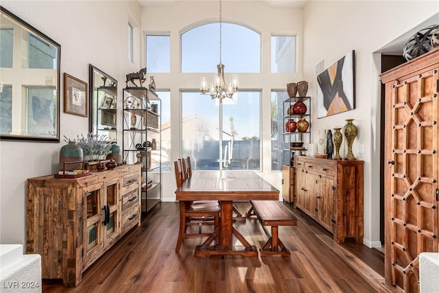 dining space featuring dark hardwood / wood-style flooring and an inviting chandelier