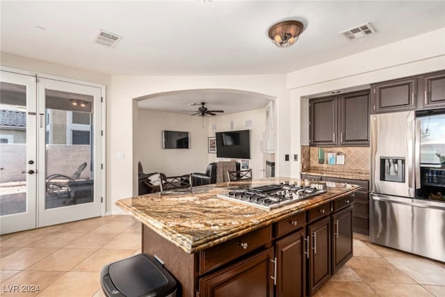 kitchen featuring appliances with stainless steel finishes, a kitchen island, french doors, and ceiling fan