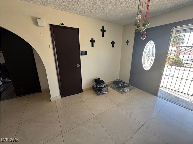 foyer entrance with a textured ceiling