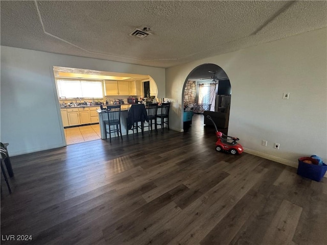 dining area featuring a textured ceiling, dark hardwood / wood-style floors, ceiling fan, and sink