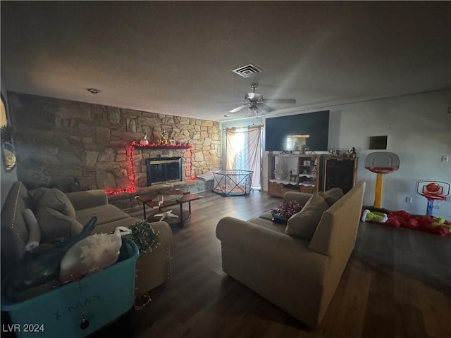 living room featuring ceiling fan, a fireplace, and dark hardwood / wood-style floors