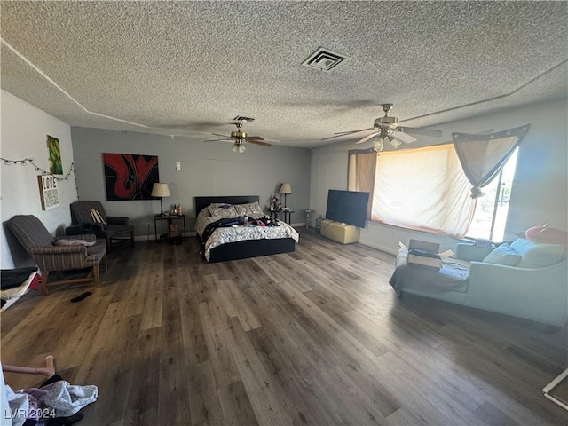 bedroom with ceiling fan, hardwood / wood-style floors, and a textured ceiling