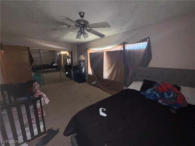 bedroom with ceiling fan, light carpet, and a textured ceiling