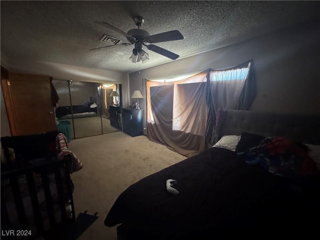 carpeted bedroom featuring ceiling fan, a textured ceiling, and a closet