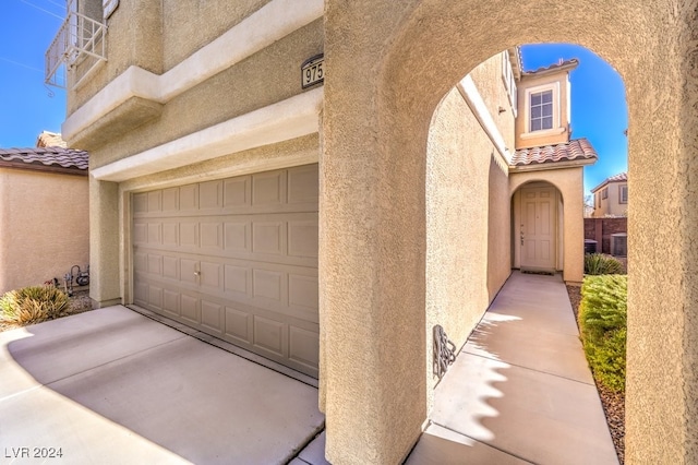 property entrance with cooling unit and a garage