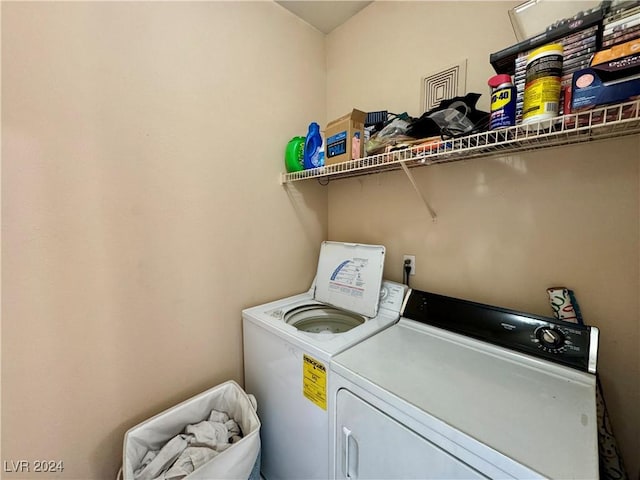 clothes washing area with washing machine and dryer