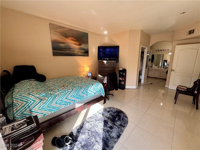 tiled bedroom featuring ensuite bathroom, a closet, and a spacious closet