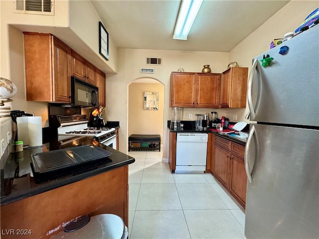 kitchen with light tile patterned floors and white appliances