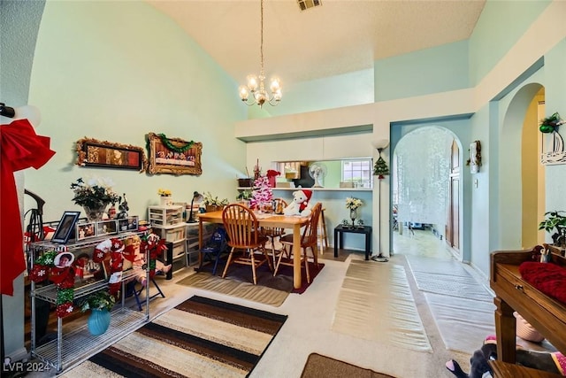 dining space featuring high vaulted ceiling, wood-type flooring, and a notable chandelier