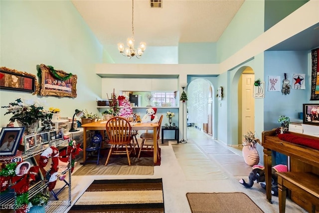 carpeted dining space with a notable chandelier and a towering ceiling