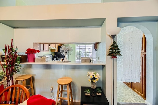 kitchen with a kitchen breakfast bar and white cabinets