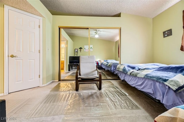 carpeted bedroom with a textured ceiling, a closet, and vaulted ceiling