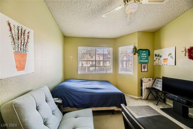 carpeted bedroom with ceiling fan and a textured ceiling