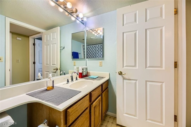 bathroom with tile patterned floors, vanity, and a textured ceiling