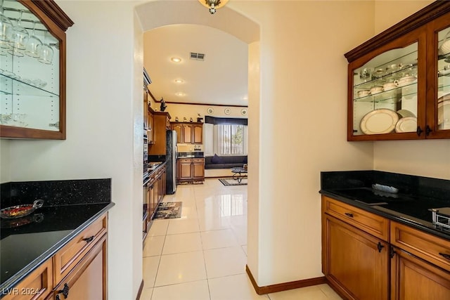 373 Via Sonador, Henderson, NV 89012 - kitchen with dark stone countertops, stainless steel fridge, and light tile patterned floors
