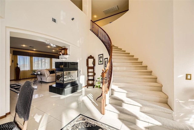 373 Via Sonador, Henderson, NV 89012 - stairway featuring tile patterned flooring, a towering ceiling, and a fireplace